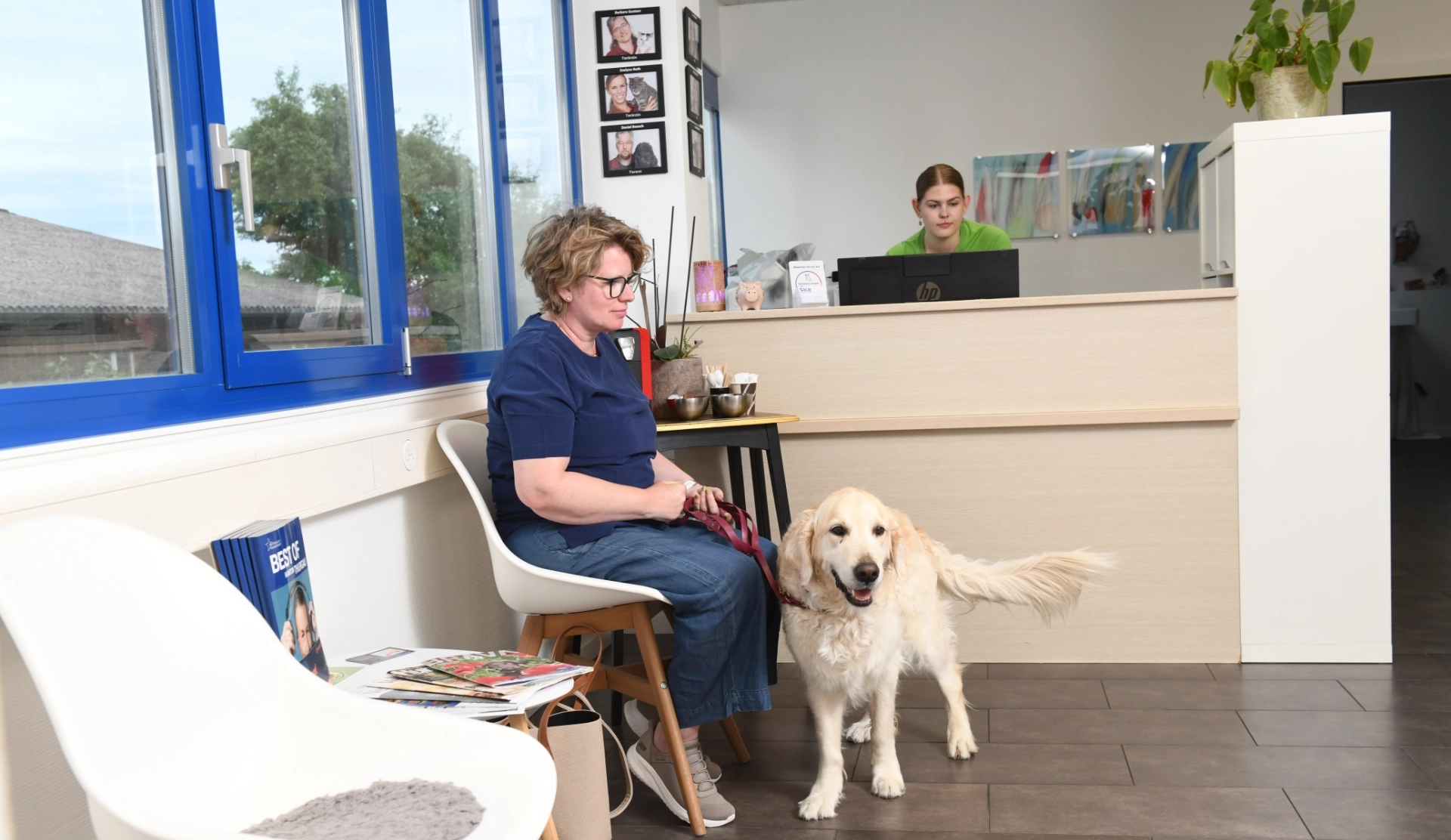 Empfangsbereich der Kleintierpraxis Lindenhof in Romanshorn mit Hundehalterin und Hund bei der Anmeldung.